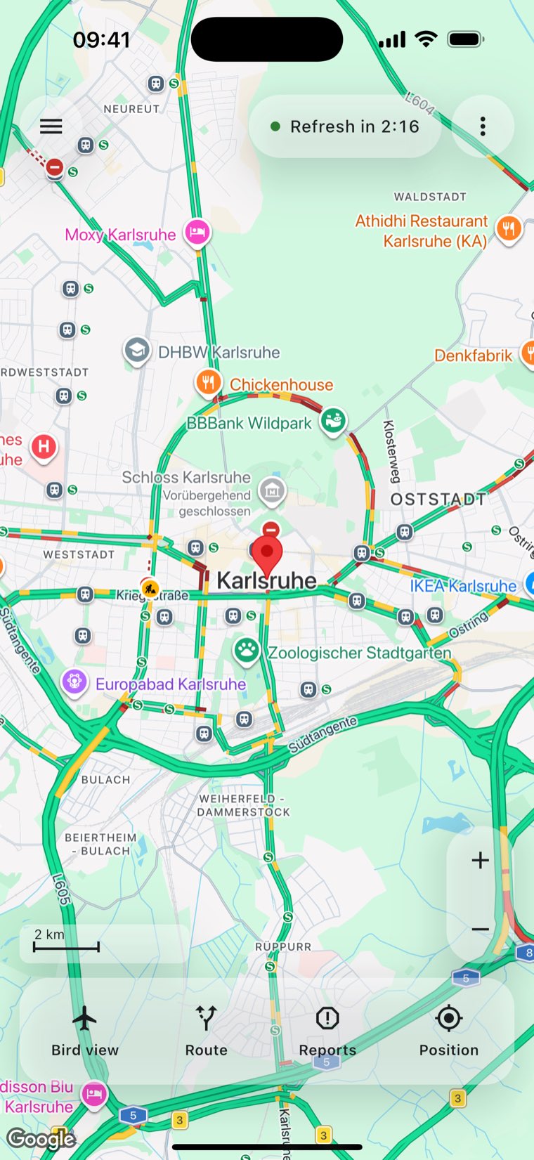 ACom's main map over Karlsruhe. Live traffic colours the roads, a countdown to the next refresh sits at the top, and four buttons — bird view, route, reports, position — run along the bottom.